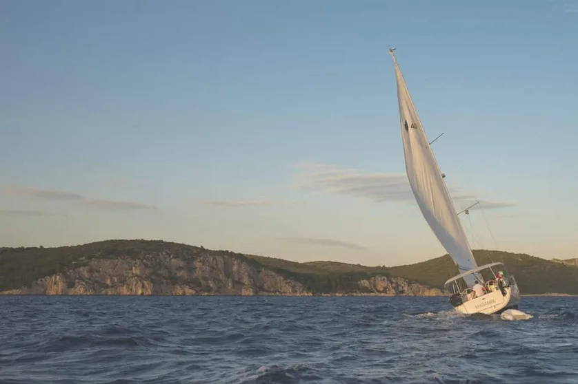 Sailing boat under sail on coastal water