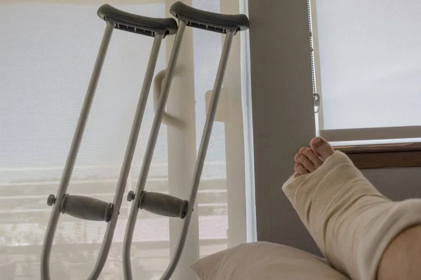 Person recovering from injury with a bandaged arm and crutches